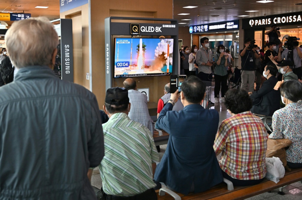 أشخاص يشاهدون بثًا مباشرًا لإطلاق كوريا الجنوبية صاروخًا فضائيًا محلي الصنع في محطة قطارات في سيول في 21 حزيران/يونيو 2022 (ا ف ب)