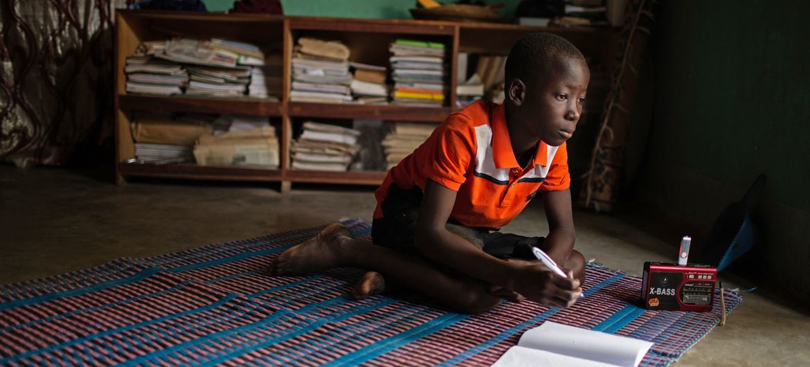 طفل صغير يدرس في منزله في دوري، بوركينا فاسو (اليونيسف)