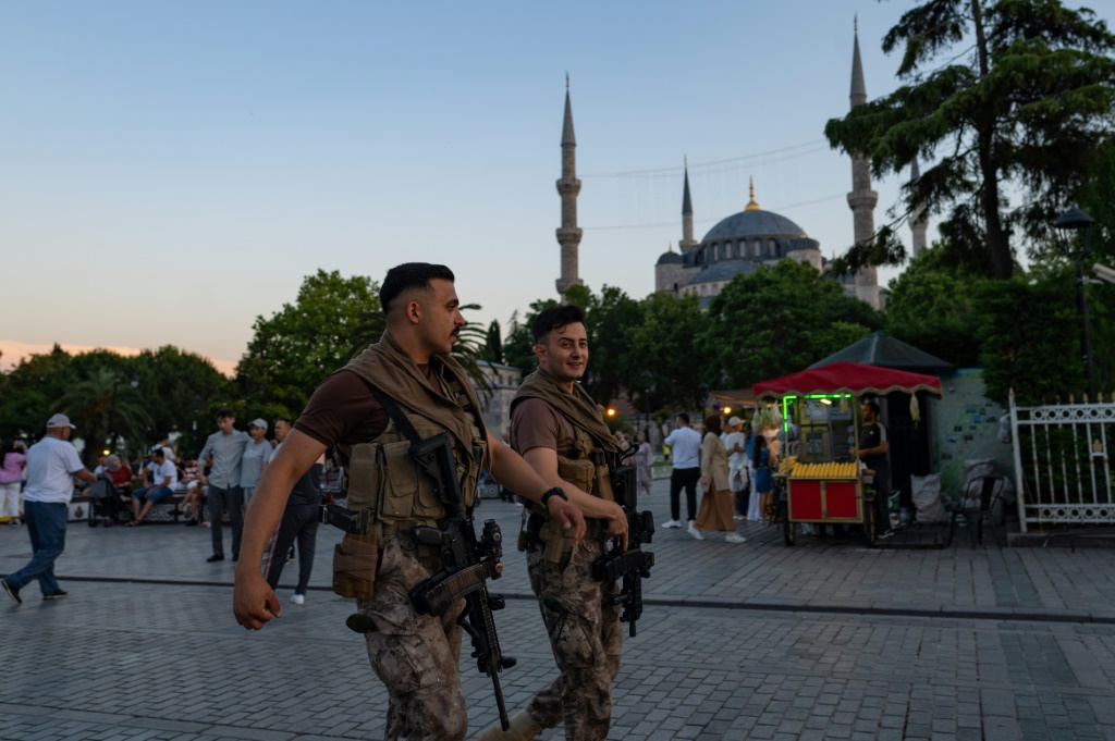    ضباط شرطة مكافحة الشغب التركية يمشون أمام المسجد الأزرق في اسطنبول (أ ف ب)