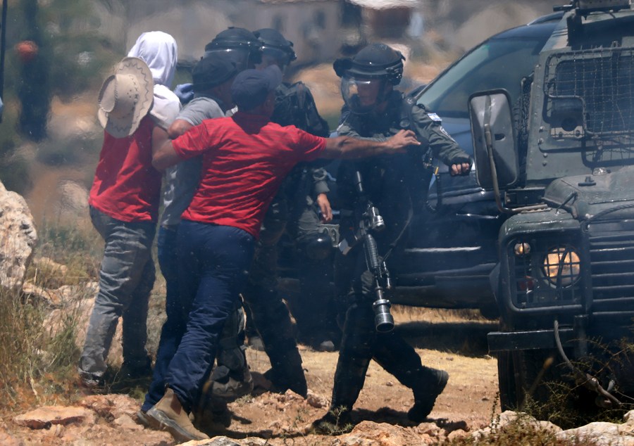 في الصورة الملتقطة يوم 11 يونيو 2022، فلسطينيون يشتبكون مع أفراد من شرطة الحدود الإسرائيلية خلال احتجاج ضد توسيع المستوطنات اليهودية في قرية ترقوميا شمال غربي مدينة الخليل بالضفة الغربية. (شينخوا)