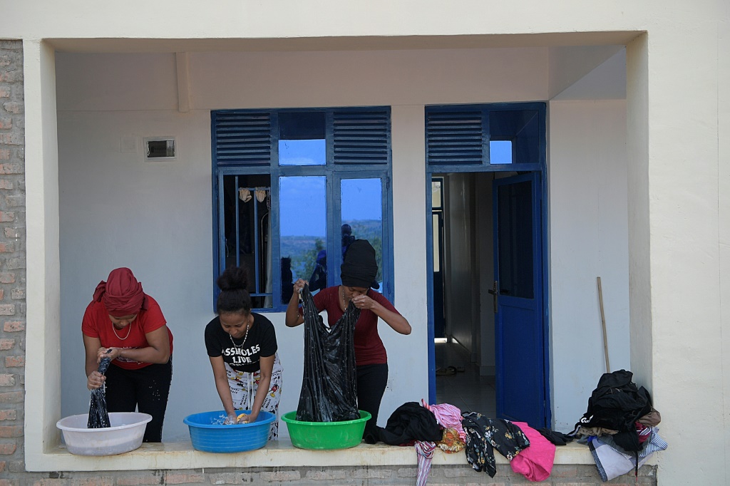 طالبو لجوء إريتريون يغسلون ملابسهم في مخيم قشورة (ا ف ب)