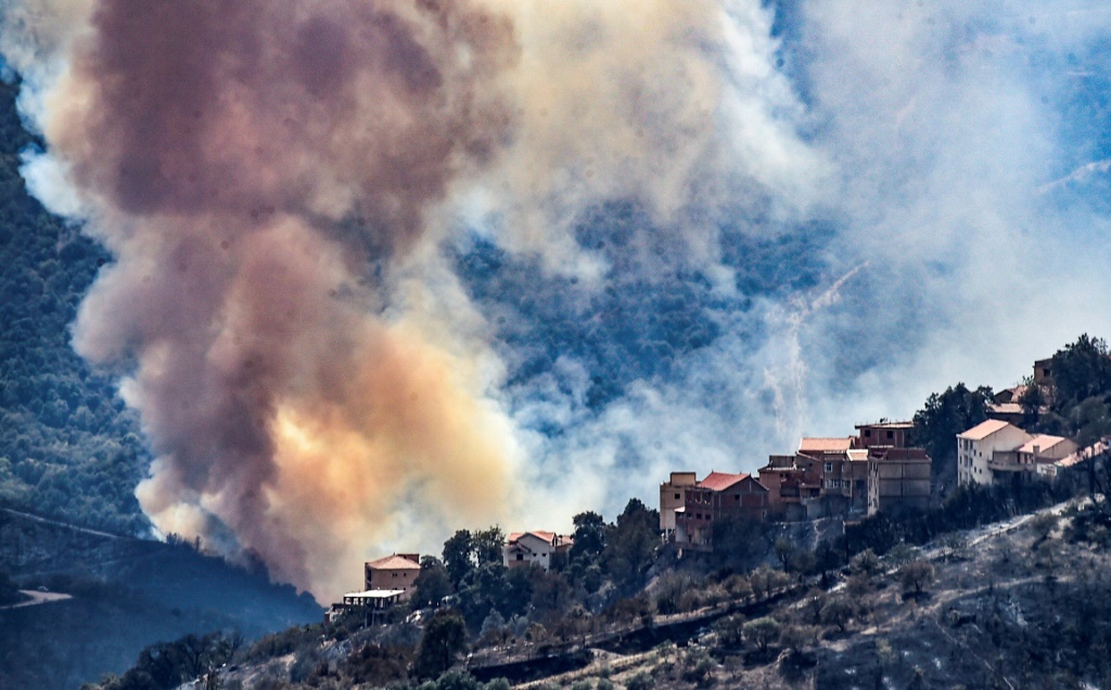 صورة من الأرشيف تُظهر دخانًا كثيفًا يتصاعد أثناء حريق في منطقة حرجية في القبائل شرق العاصمة الجزائرية في 11 آب/أغسطس 2021 (ا ف ب)