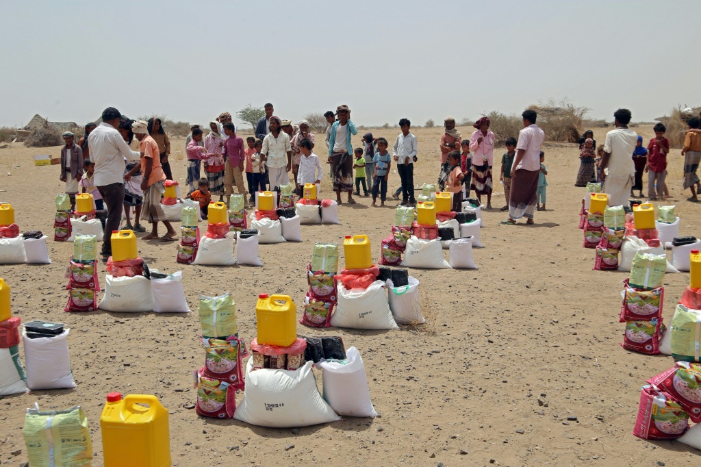 نازحون يمنيون بسبب النزاع في بلدهم يتسلمون حصصهم الغذائية في مخيم في محافظة الحديدة (غرب) في 29 آذار/مارس 2022 (ا ف ب)