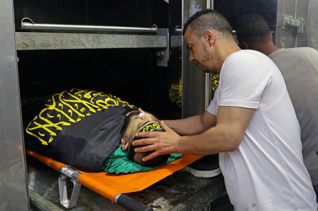أحد اقارب الشاب محمد مرعي (25 عاما) الذي قتل برصاص الجيش الإسرائيلي فجر 29 حزيران/يونيو 2022 يلقي نظرة الوداع على جثمانه في مستشفى جنين الحكومي في مدينة جنين شمال الضفة الغربية المحتلة (ا ف ب)