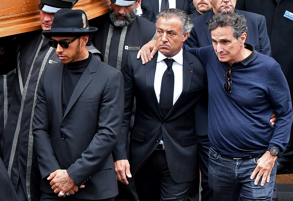 سائق الفورمولا واحد السابق البرازيلي نيلسون بيكيت (إلى اليمين) إلى جانب الفرنسي جان أليزي والبريطاني لويس هاميلتون خلال مراسم دفن البطل السابق النمسوي نيكي لاودا في كاتدرائية سان-إتيان في فيينا في 29 أيار/مايو 2019 (ا ف ب)