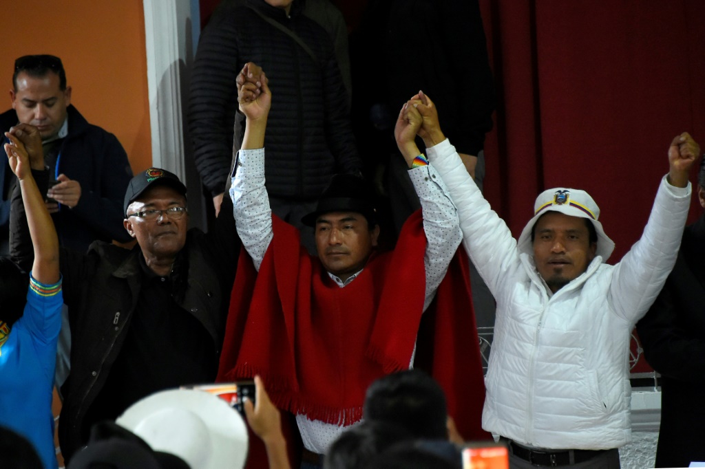  زعيم السكان الأصليين ليونيداس إيسا (وسط) ومسؤولون آخرون للسكان الأصليين يرفعون أياديهم بعد توقيع اتفاق مع الحكومة يضع حدا للتظاهرات احتجاجا على غلاء المعيشة في 30 حزيران/يونيو 2022 في كيتو في الأكوادور (ا ف ب)