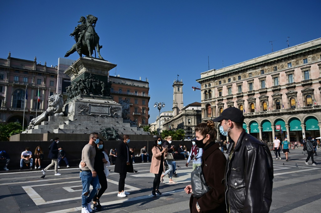 أشخاصٌ يضعون كِمامات في ساحة بيازا ديل ديومو في ميلانو في 17 تشرين الأول/أكتوبر 2020. (أ ف ب)