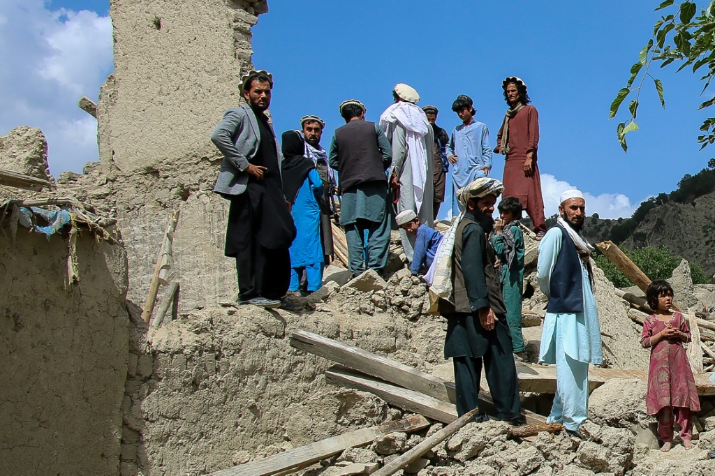 أفغان يقفون على أنقاض منزل دُمّر جراء الزلزال في منطقة غايان في شرق أفغانستان في 24 حزيران/يونيو 2022 (ا ف ب)