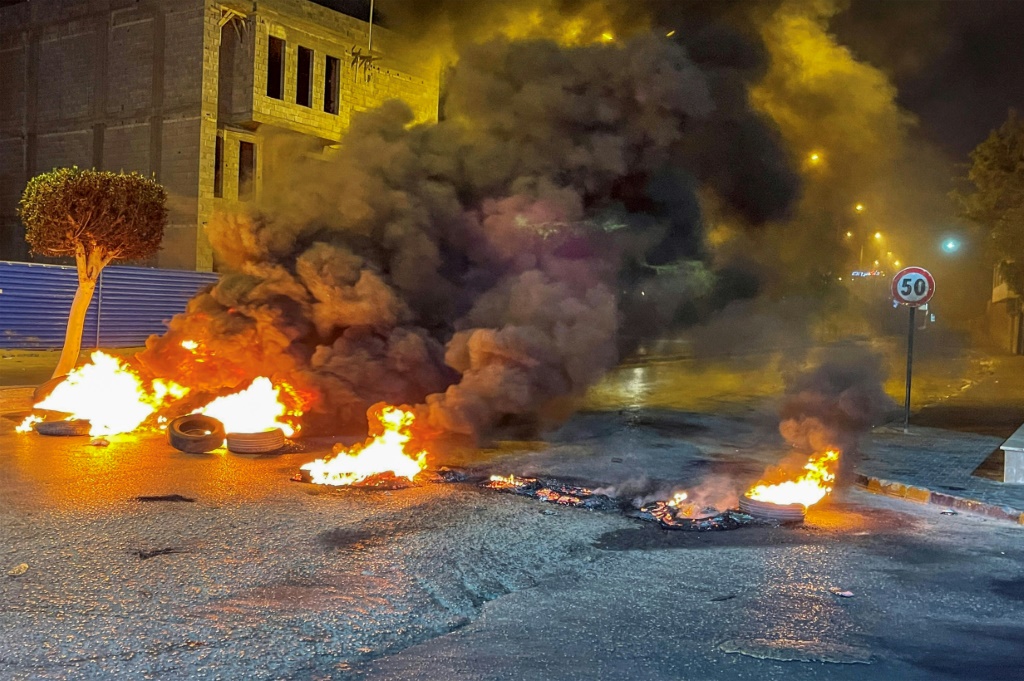 صورة التفطت في 3 حزيران/يونيو 2022 لإطارات محترقة تغلق الطرق خلال احتجاجات ليلية في العاصمة الليبية طرابلس (اف ب)