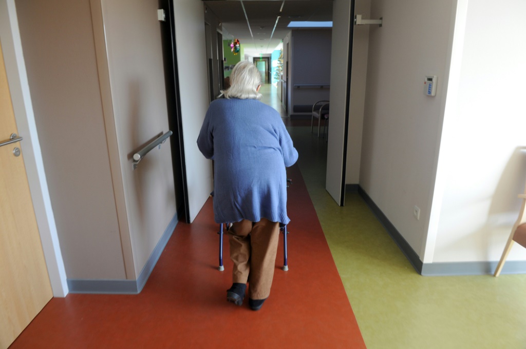  امرأة مسنة تمشي متكئة على جهاز مساعدة على المشي عام 2011 (ا ف ب)