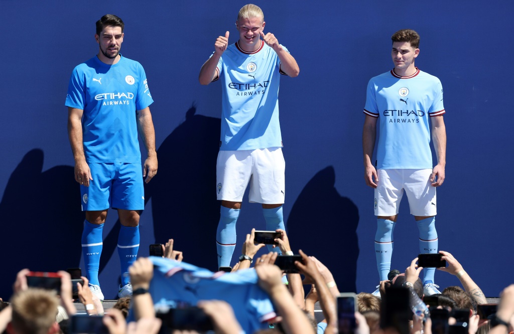 مهاجم مانشستر سيتي الانكليزي الوافد الجديد النروجي إرلينغ هالاند متوسطاً حارس المرمى الألماني ستيفان أورتيغا والمهاجم الأرجنتيني جوليا ألفاريس خلال حفل التقديم الرسمي على ملعب الاتحاد في 10 تموز/يوليو 2022 (ا ف ب)