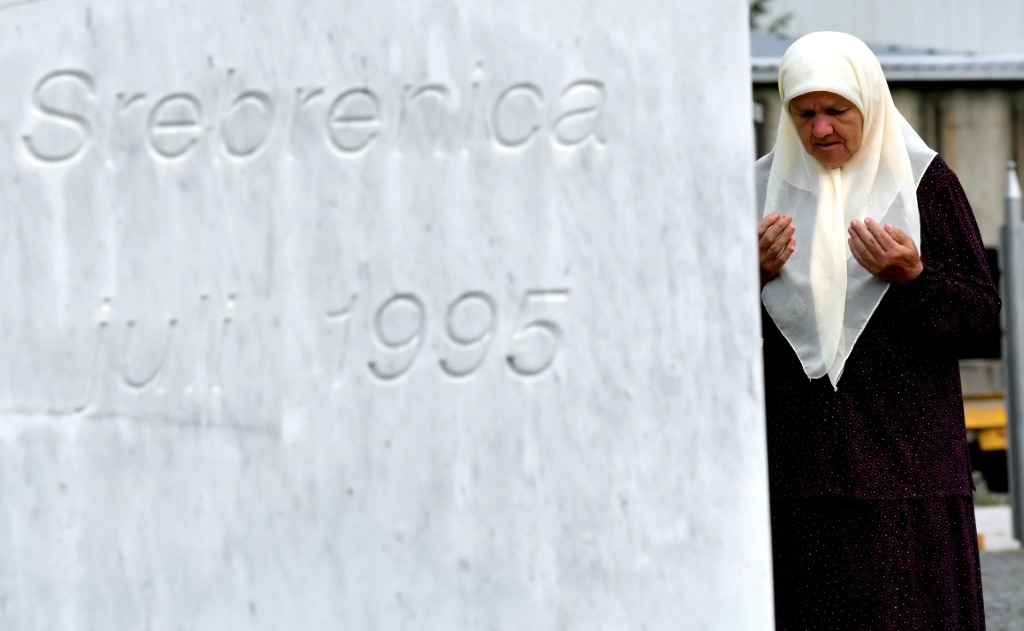 ميريا دجوغاز (71 عاما) من مسلمي البوسنة تصلي عند قبري نجليها اللذين قتلا في مجزرة سريبرينيتسا، في النصب التذكاري قرب المدية في 03 تموز/يوليو 2020 (اف ب)