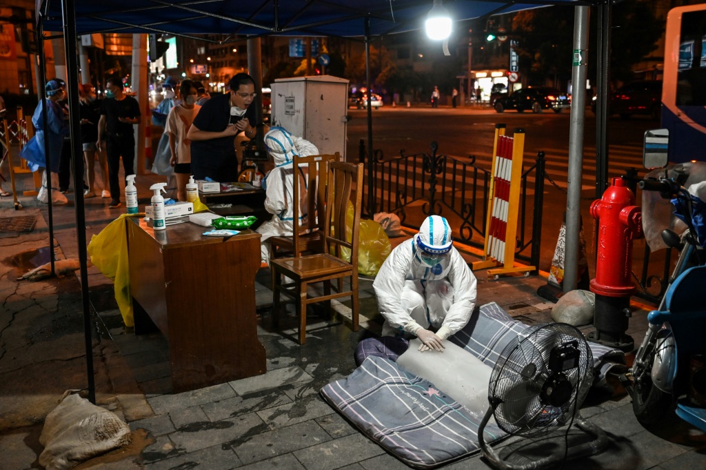 جلس العاملون في مجال الصحة في شنغهاي أو استلقوا على كتل من الجليد ليبردوا أثناء قيامهم بإجراء اختبار شامل (أ ف ب)   