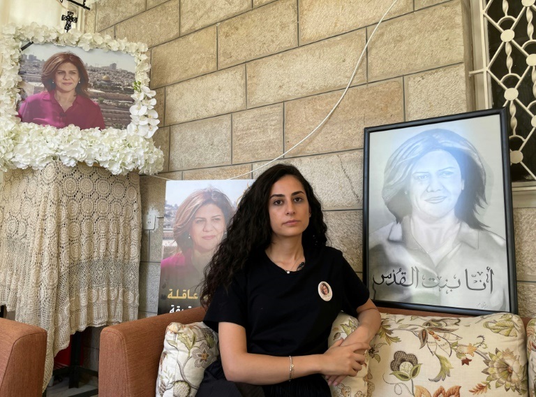 ابنة شقيق الصحافية شيرين أبو عاقلة لينا تجلس في منزل العائلة محاطة بصور الصحافية الراحلة في القدس الشرقية في 13 تموز/يوليو 2022 بالتزامن مع زيارة الرئيس الأميركي جو بايدن إلى إسرائيل (ا ف ب)