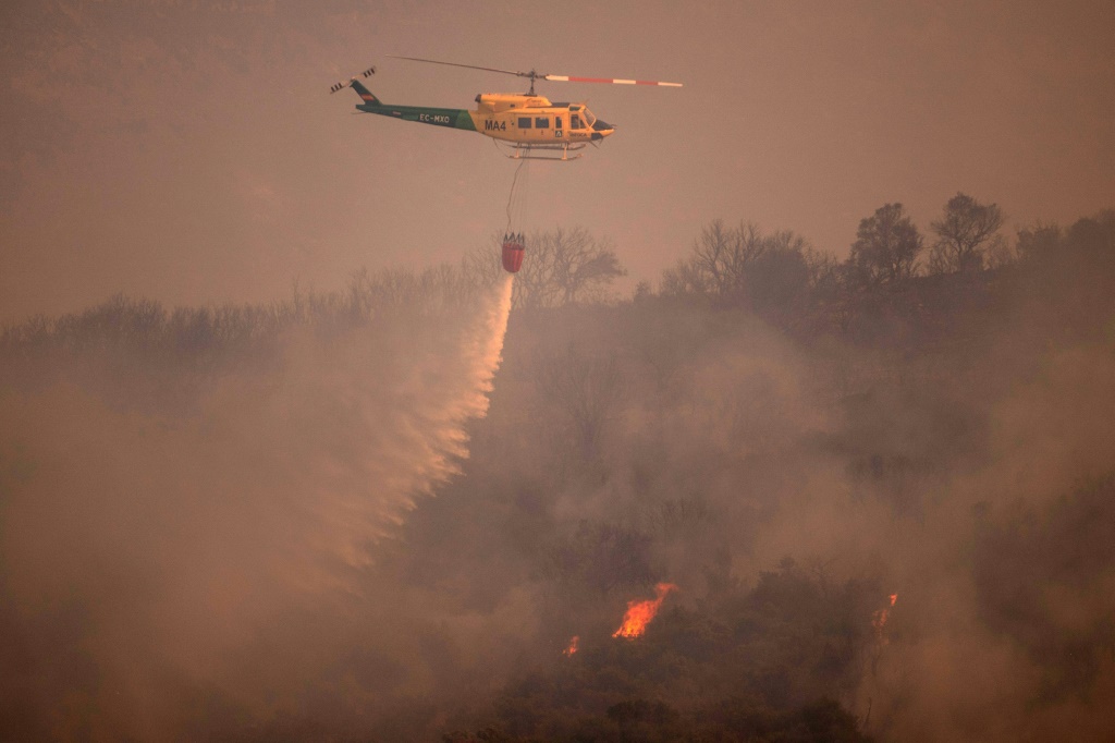 طائرة هليكوبتر تخمد حريق هائل في مقاطعة ملقة الإسبانية في 15 يوليو (أ ف ب)