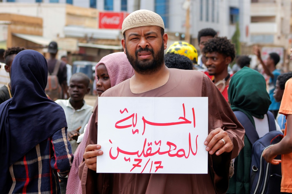 متظاهر سوداني يحمل لافتة تطالب بالافراج عن المعتقلين في الخرطوم في 17 تموز/يوليو 2022 (ا ف ب)
