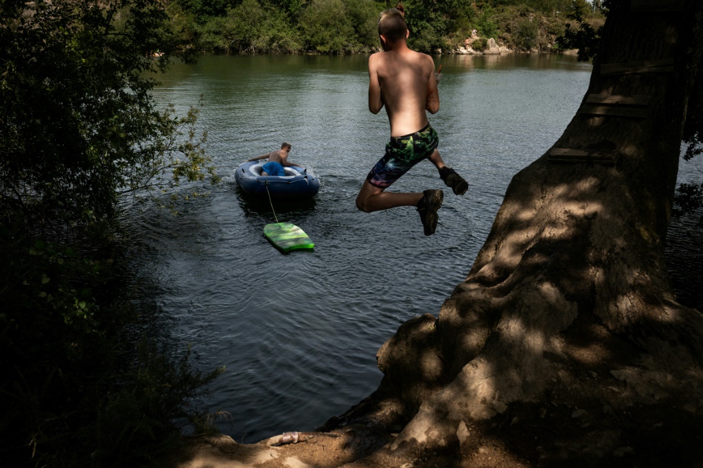 شاب يغطس في بحيرة اصطناعية في لافو-سور لوار في غرب فرنسا خلال موجة حر تضرب البلاد في 17 تموز/يوليو 2022 (ا ف ب)