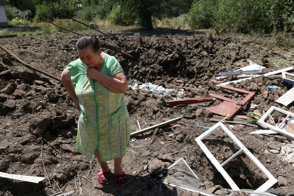  امرأة تقف وسط الأنقاض إثر قصف روسي قرب منزلها في توريتسك في منطقة دونيتسك في شرق أوكرانيا في 17 تموز/يوليو 2022 (ا ف ب)