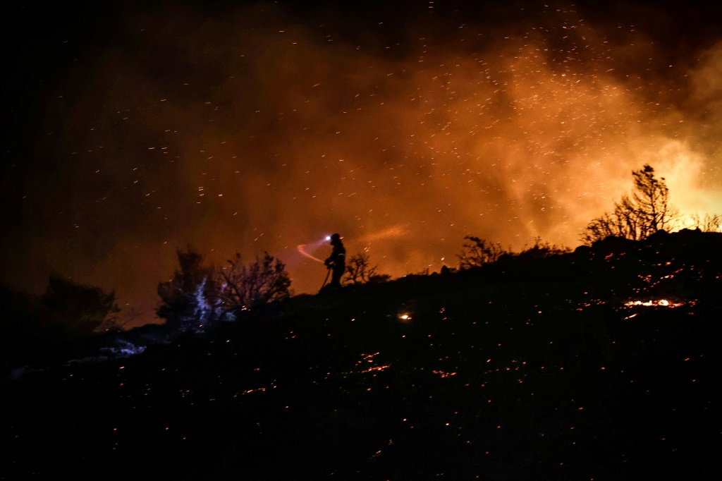 اشتعال  حرائق الغابات على سفح جبل بنتيلي شمال أثينا بين عشية وضحاها بسبب الرياح (ا ف ب).