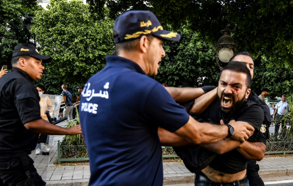 عنصر من الشرطة التونسية يوقف متظاهرًا في 22 تموز/يوليو 2022 أثناء تظاهرة في العاصمة تونس ضد الرئيس قيس سعيد (ا ف ب)