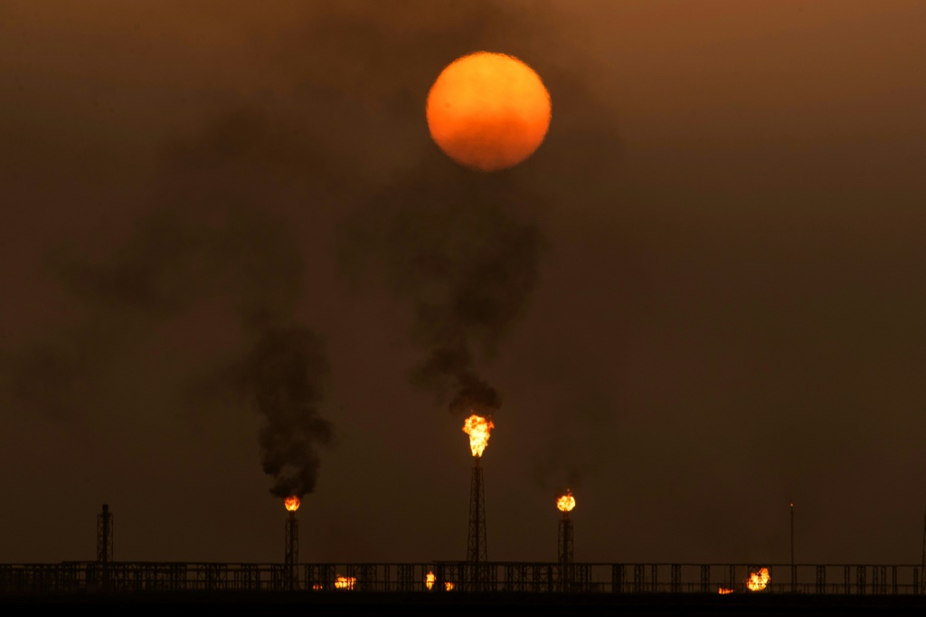 غروب الشمس عند حقل الزبير النفطي في البصرة في جنوب العراق بتاريخ 13 تموز/يوليو 2022 (ا ف ب)