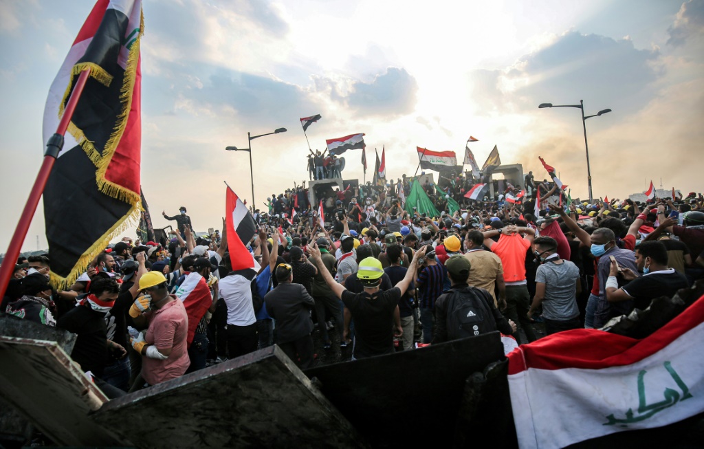 صورة من الارشيف لمتظاهرين عراقيين يلوحون باعلام البلاد في العاصمة بغداد في 29 تشرين الاول/اكتوبر 2019 ( ا ف ب).
