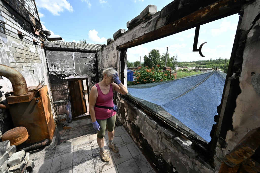 غاليانا البالغة 67 عاما تزيل الركام عن منزلها الذي لحقت به أضرار جسيمة في بلدة مالا روغان في منطقة خاركيف في شرق أوكرانيا في 28 تموز/يوليو 2022 (ا ف ب)