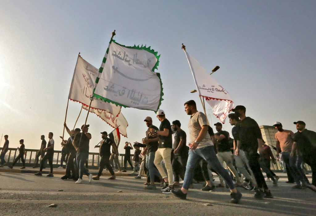 أنصار رجل الدين العراقي مقتدى الصدر يرفعون الأعلام خلال تجمع احتجاجي على ترشيح كتلة سياسية منافسة لرئاسة الوزراء يوم الاثنين. (ا ف ب)
