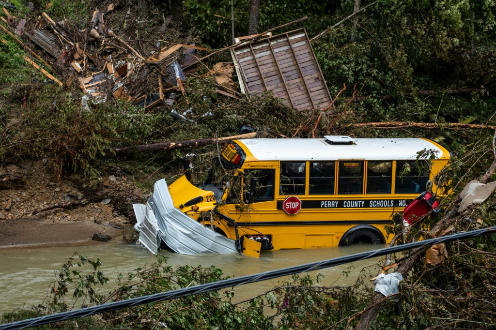 حافلة مدرسية وحطام آخر يجلس في خور بالقرب من جاكسون بولاية كنتاكي بعد فيضانات مفاجئة مدمرة (ا ف ب)