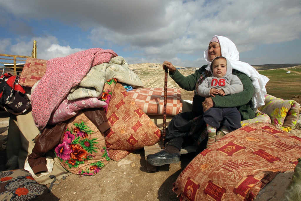 فلسطينية تجلس امام امتعتها بعد ان تم هدم منزلها في خربة جنبه بالقرب من مدينة يطا جنوب الضفة الغربية (ا ف ب)