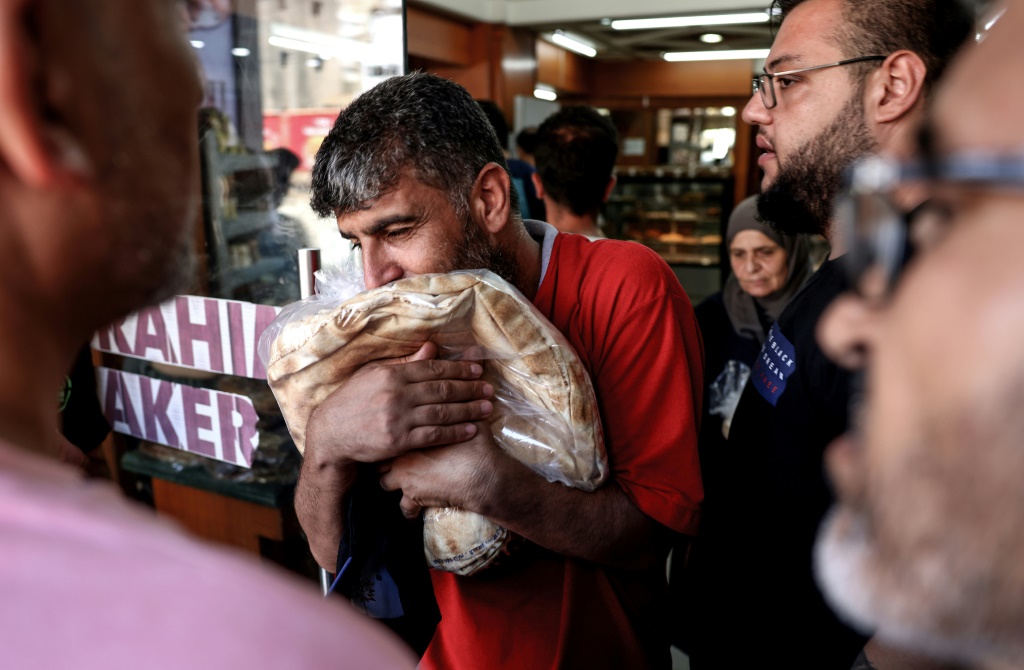 رجل يتشبث بربطة خبز لدى خروجه من مخبز في بيروت في 29 تموز/يوليو 2022 (ا ف ب)