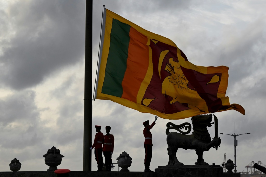 عسكريون سريلانكيون يخفضون العلم الوطني السريلانكي في كولومبو في 23 تموز/يوليو 2022 (ا ف ب)