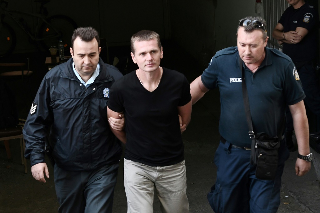 صورة التُقطت في 4 تشرين الأول/أكتوبر 2017 تُظهر الخبير الروسي بالعملات المشفّرة ألكسندر فينيك برفقة عنصريْن من الشرطة لدى وصوله إلى محكمة في سالونيكي في اليونان (ا ف ب)