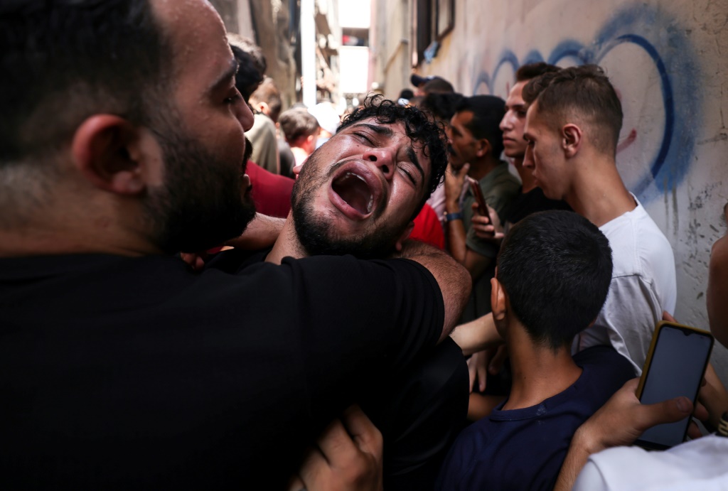 فلسطيني ينتحب خلال جنازة صديقه الذي قتل ليلا في مخيم جباليا شمال قطاع غزة، في 7 آب/أغسطس 2022 (أ ف ب)