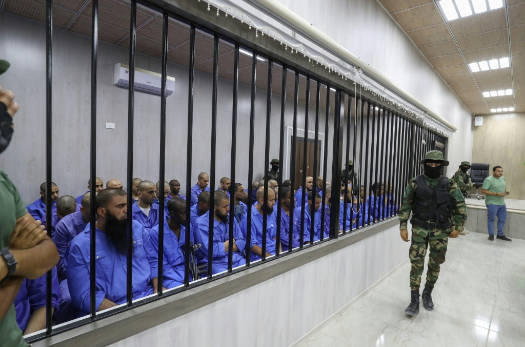  أشخاص يشتبه بانتمائهم غلى تنظيم الدولة الإسلامية داخل قفص الاتهام في مصراتة بتاريخ 8 آب/اغسطس 2022 (إ ف ب)