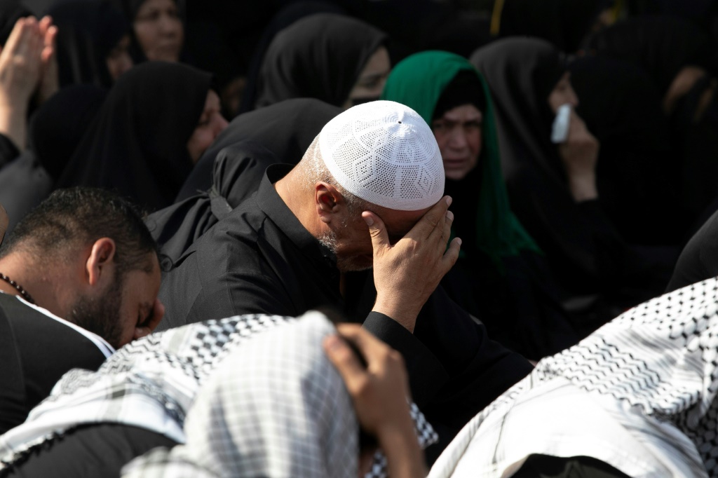 رجل يبكي متأثراً فيما يصغي إلى رواية واقعة مقتل الإمام الحسين في كربلاء في 9 آب/أغسطس 2022 (ا ف ب)