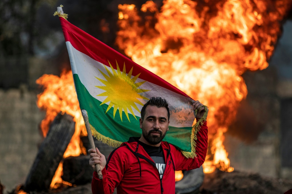 شخص يرفع العلم الكردي لمناسبة عيد النوروز في القامشلي بتاريخ 20 آذار/مارس 2020 (أ ف ب)   