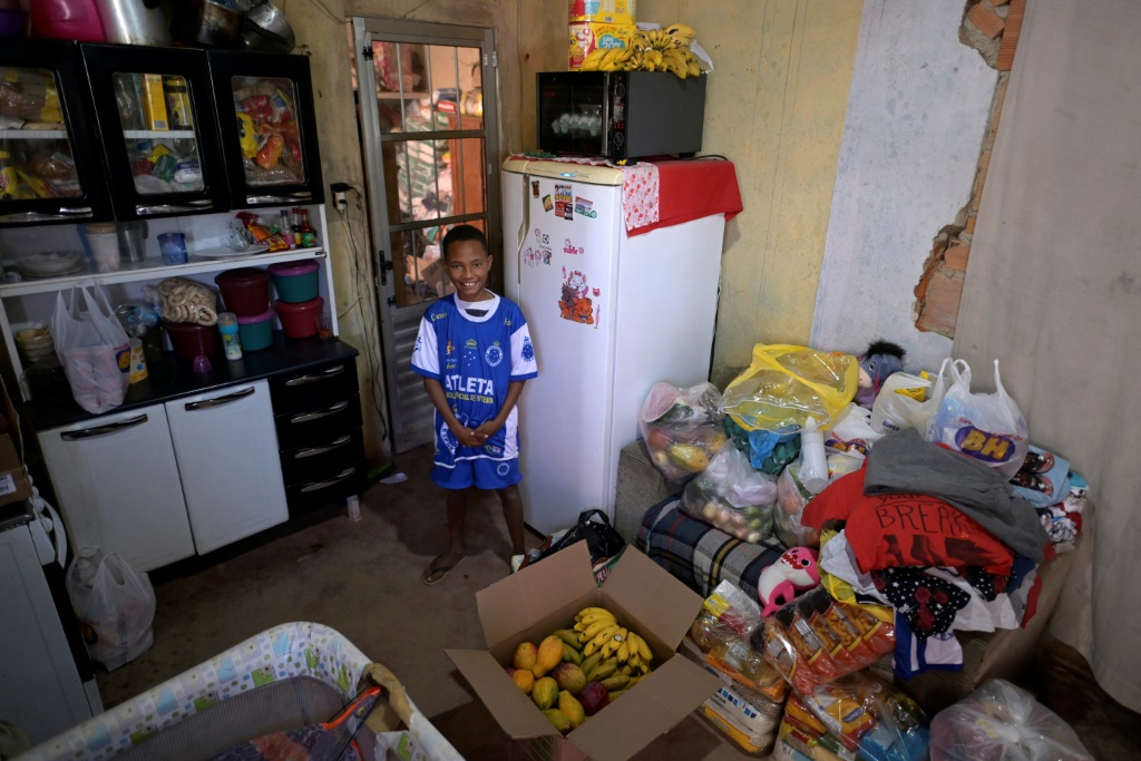 الفتى ميغال من مطبخ منزله الذي أصبح ممتلئاً بالمواد الغذائية في 6 آب/أغسطس 2022 (ا ف ب)