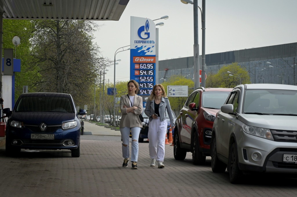 نساء يسِرن أمام محطة محروقات تابعة لشركة إنتاج النفط الروسية 