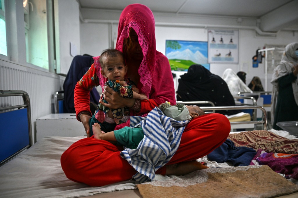    صورة ملتقطة في 21 تموز/يوليو 2022 تظهر بريشنا على فراش مع طفليها التوأمين في قسم سوء التغذية في مستشفى بوست الذي تديره منظمة "أطباء بلا حدود" في محافظة هلمند في جنوب أفغانستان (أ ف ب)