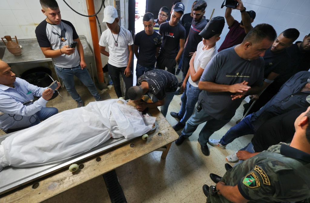 فلسطينيون حول جثمان شاب يرقد في مشرحة بعد مقتله خلال مواجهات مع القوات الإسرائيلية في نابلس بالضفة الغربية المحتلة في 18 آب/أغسطس 2022 (أ ف ب)