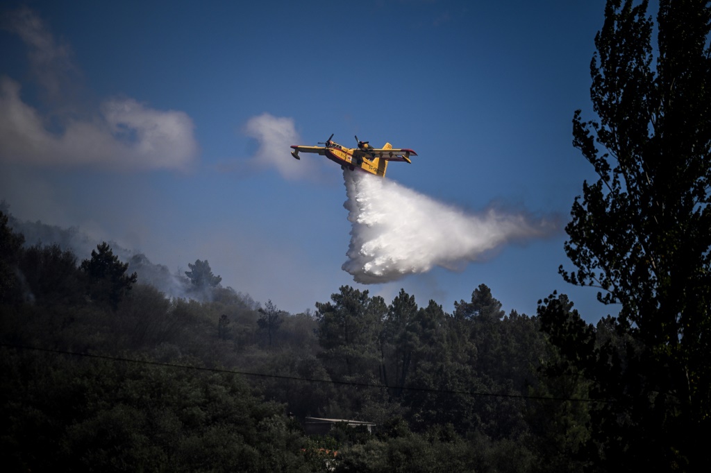 طائرة تقذف المياه على حريق في غابة في شرق منتزه سيرا دا استريلا في وسط البرتغال في 17 آب/أغسطس 2022 ( ا ف ب    )
