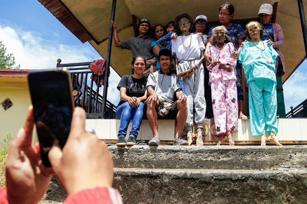 عائلة إندونيسية خلال التقاط صورة لها مع أقربائها المتوفين في إطار احتفال 