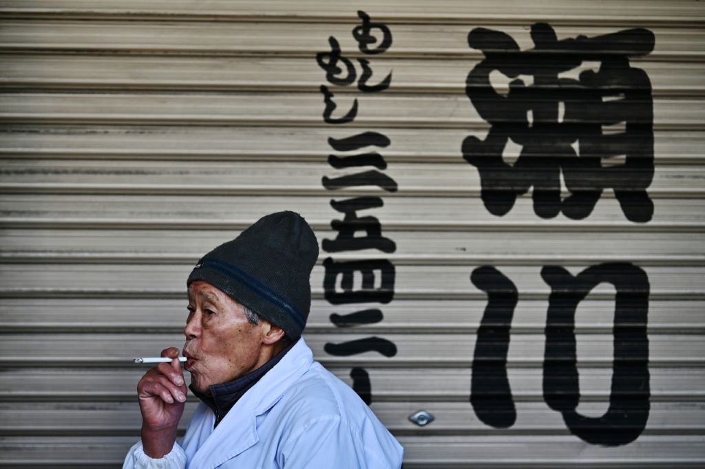 رجل مسن يدخن سيجارة في منطقة تسوكيجي في طوكيو في 10 كانون الثاني/يناير 2020 (ا ف ب)