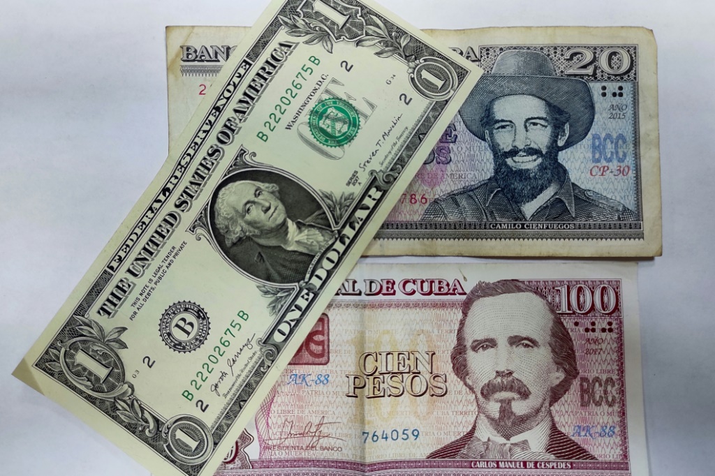  ورقة مالية بقيمة دولار واحد وورقتان ماليتان كوبيتان في هافانا في 4 آب/أغسطس 2022 (ا ف ب)