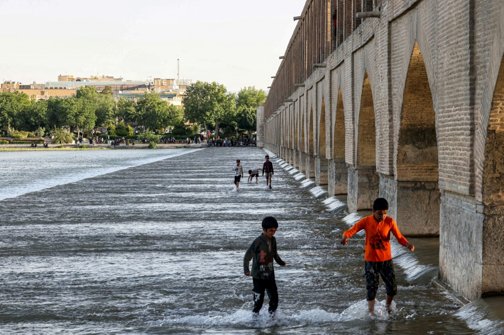 أطفال يلعبون في نهر زاينده في مدينة اصفهان الايرانية في 15 أيار/مايو 2022 (أ ف ب)   