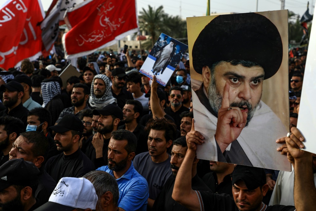 متظاهرون يرفعون صورة مقتدى الصدر في الناصرية في جنوب العراق بتاريخ 12 آب/أغسطس 2022 (ا ف ب)