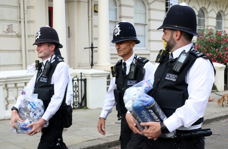 شرطيون يحملون عبوات من أكسيد النيتريك (غاز الضحك) صادروها خلال كرنفال نوتينغ هيل في لندن في 29 آب/أغسطس 2022 (أ ف ب)