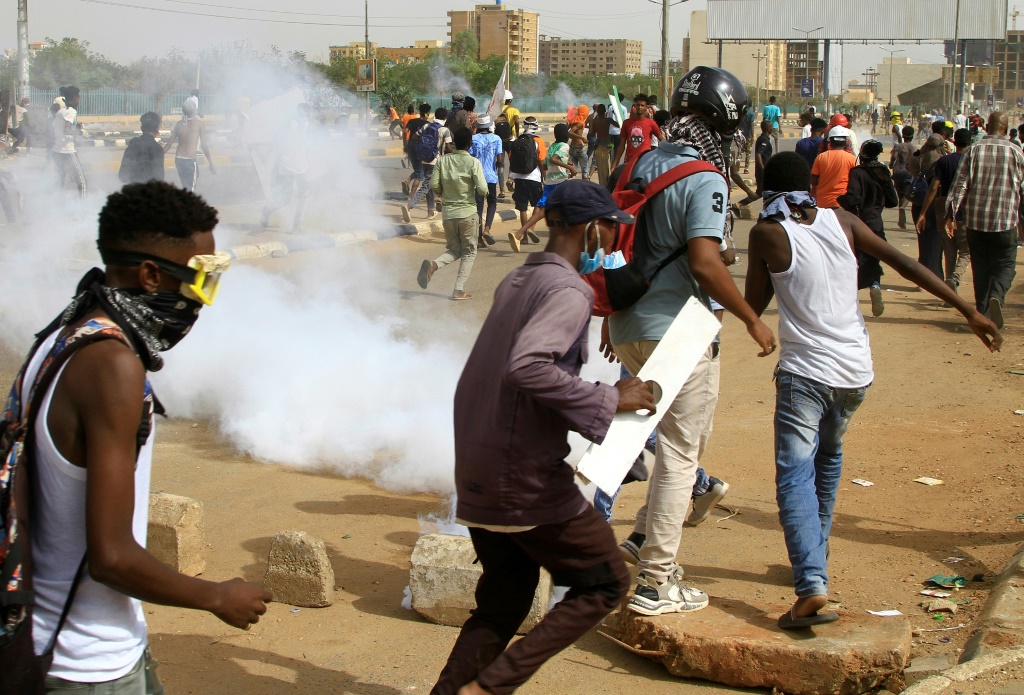 شبان سودانيون يفرون من الغاز الذي اطلقته قوات الامن خلال احتجاجات قرب المطار جنوب العاصمة الخرطوم في 31 آب/اغسطس 2022 (أ ف ب)   