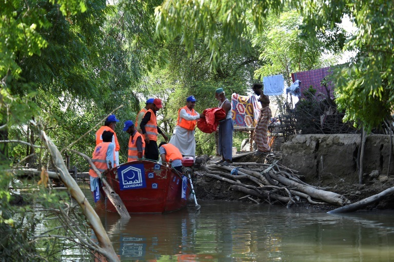 صورة مؤرخة في 31 آب/أغسطس 2022 لمتطوعين من منظمة "الخدمة" الباكستانية يقدمون المساعدة لسكان غرقت قراهم بالفيضانات التي ضربت البلاد (أ ف ب)
